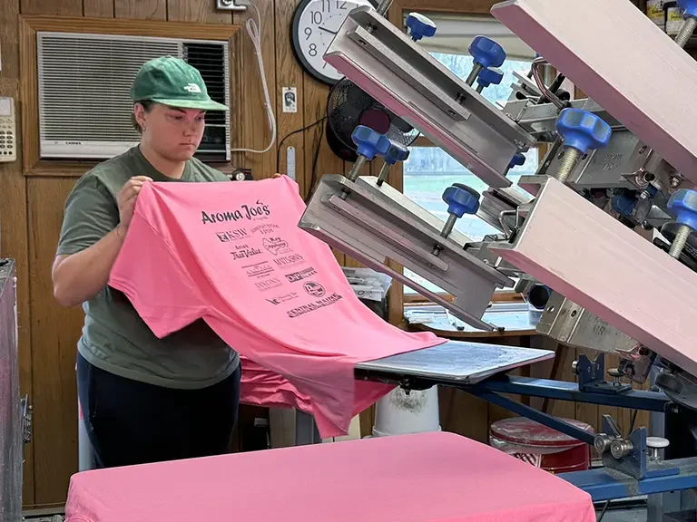 Ashlyn pressing logos onto a shirt.