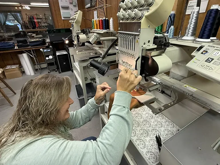 Julie embroidering a piece of fabric.